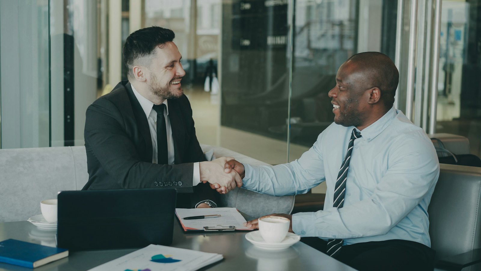 Attorney shaking hands with a client across a conference table